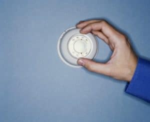 Man's hand adjusting thermostat