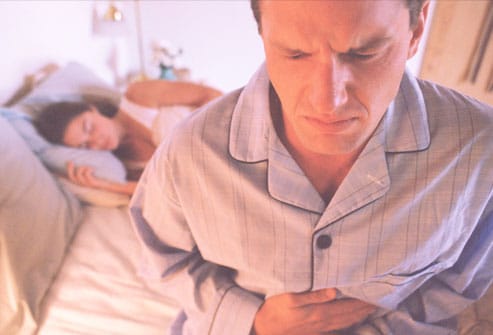 Man in bed suffering acid reflux