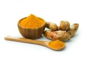 Bowl of turmeric powder and turmeric root