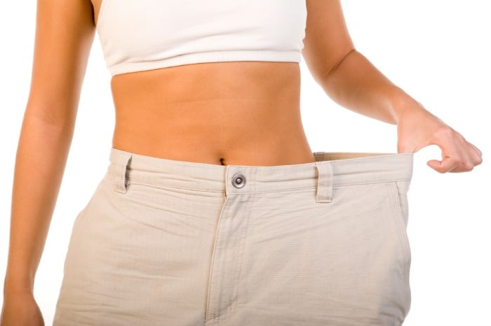 woman pulling out waistband of pants