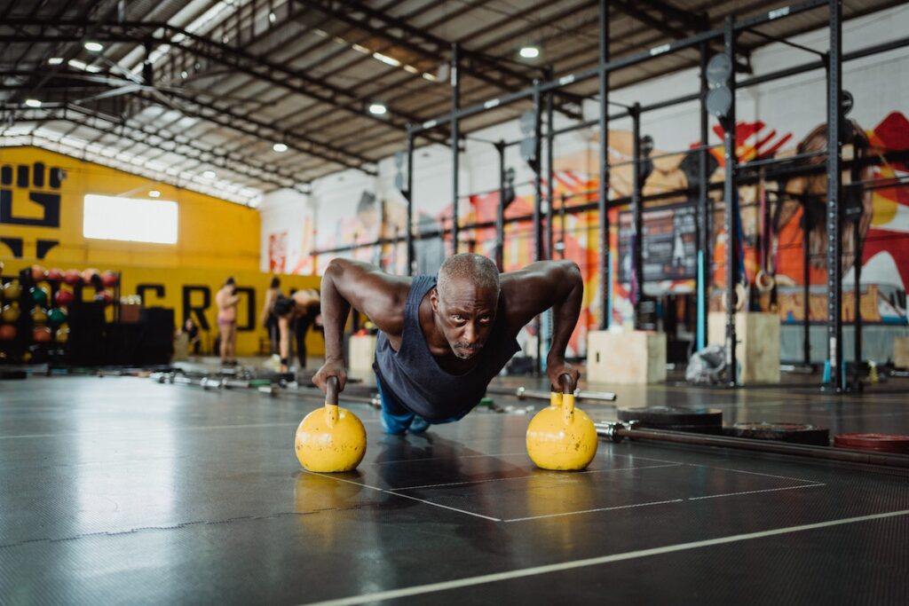 Image of a man doing kettlebell pushup. Source: Pexels.