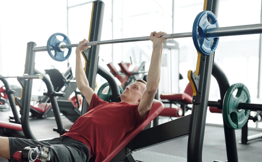 Image of a man lifting a barbell on a bench press from Pexels.