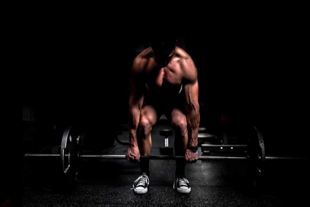 Image of a weightlifter lifting a dumbbell. Source: Unsplash