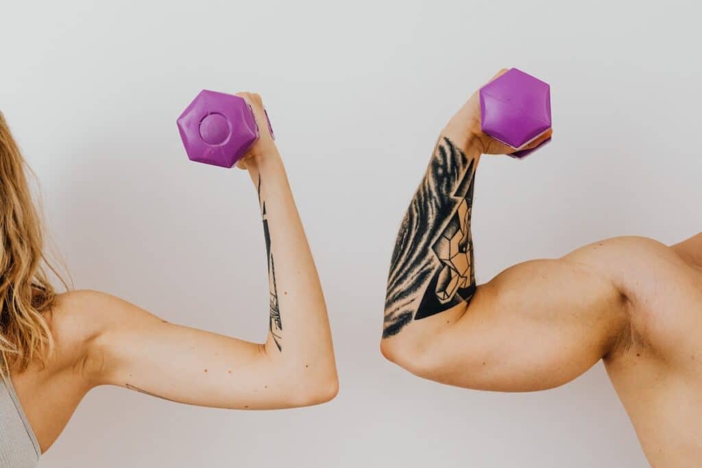 Image of a woman and a man holding dumbbells. Source: Pexels