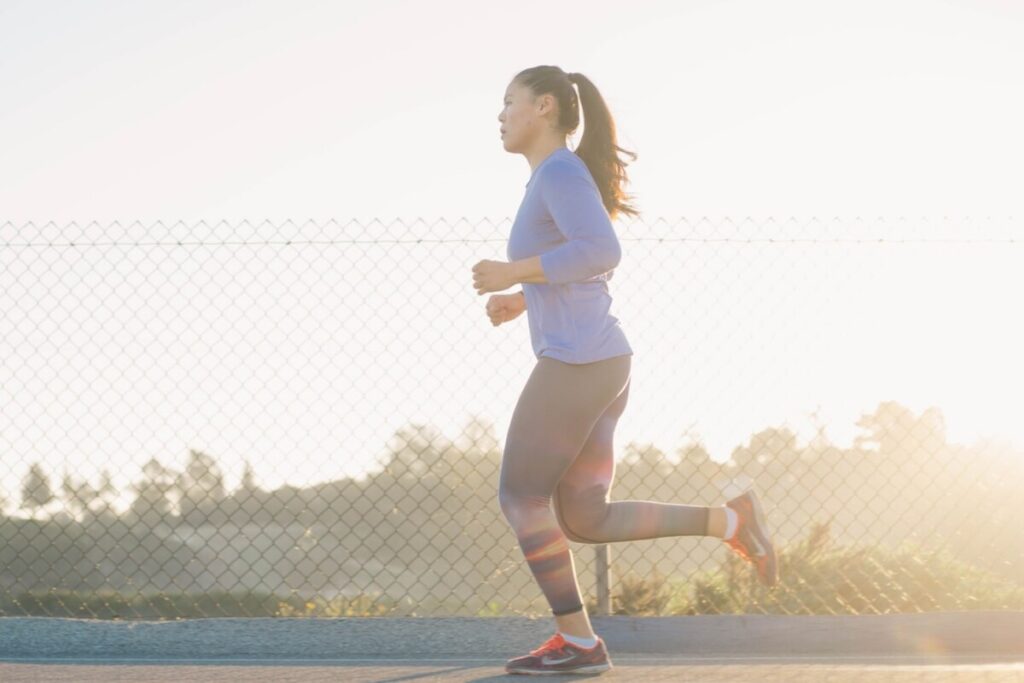 Image of a woman jogging on the street. Source: Unsplash - How Long Does It Take to Get in Shape