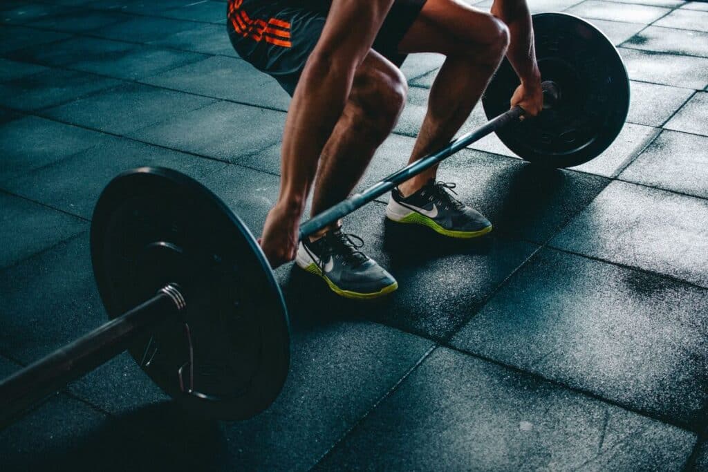 Image of a man lifting weights. Source: Unsplash