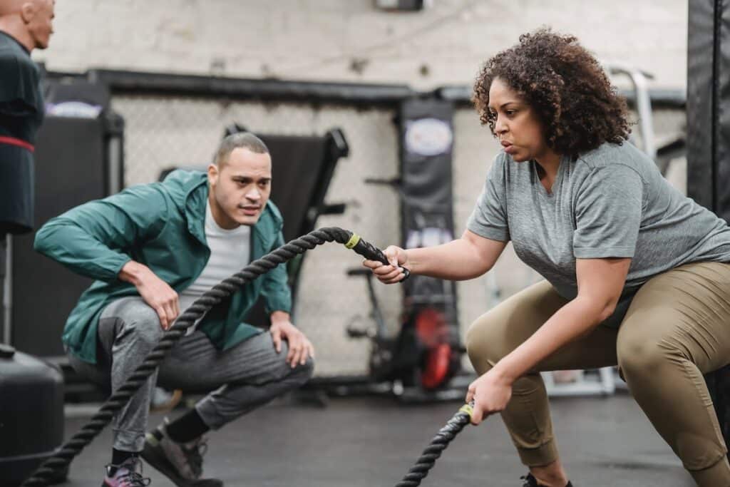 Image of a woman working out using a battle rope. Photo source: Pexels
