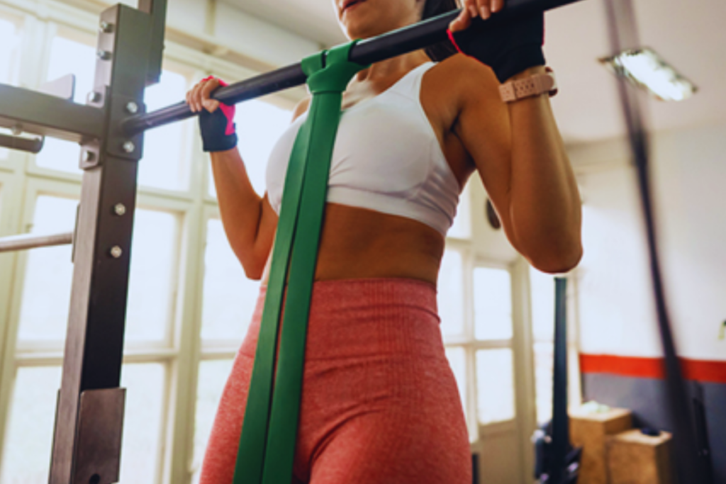 Young fit woman doing resistance band assisted pull-ups exercise in gym. Source: iStock by Getty Images