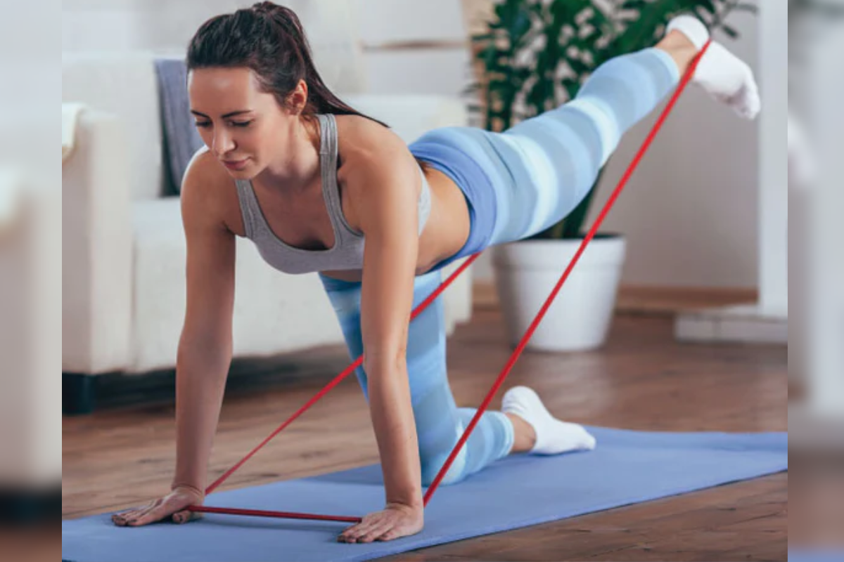 Sporty athletic woman exercising with rubber tape. Image source: iStock by Getty Images