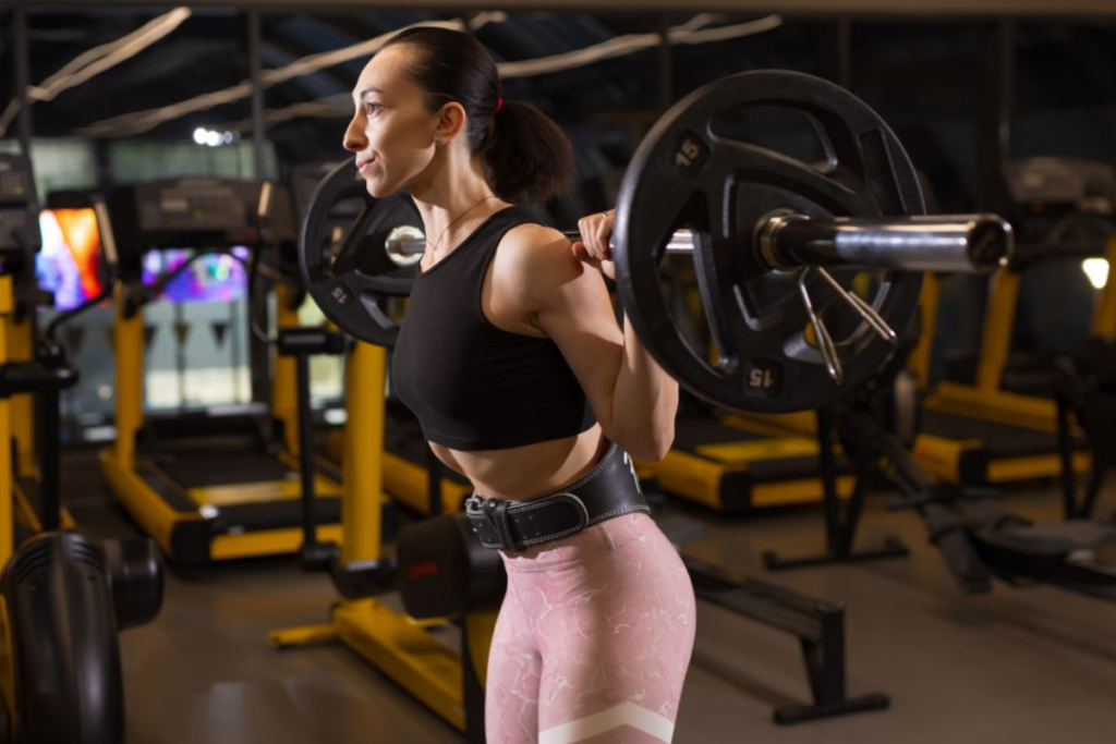Woman squats with heavy weight on bar in a gym. Image source: iStock by Getty Images