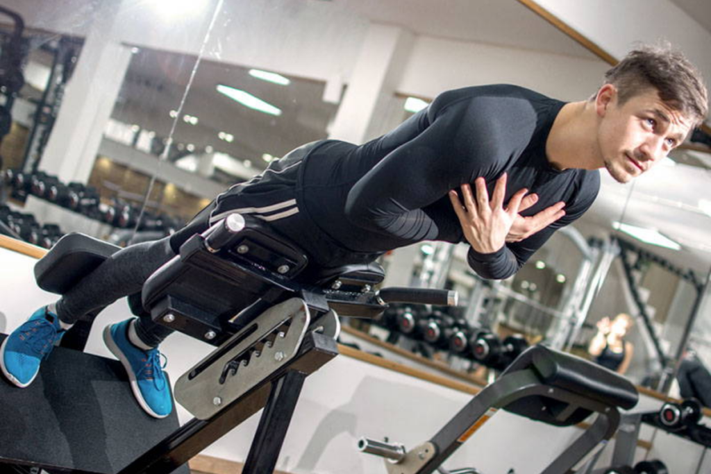 Young handsome fit man performing back-extension exercise on roman chair in a gym Image source: iStock by Getty Images