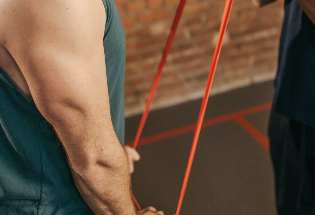 Image of a man pulling down a resistance band. Image source: Pexels