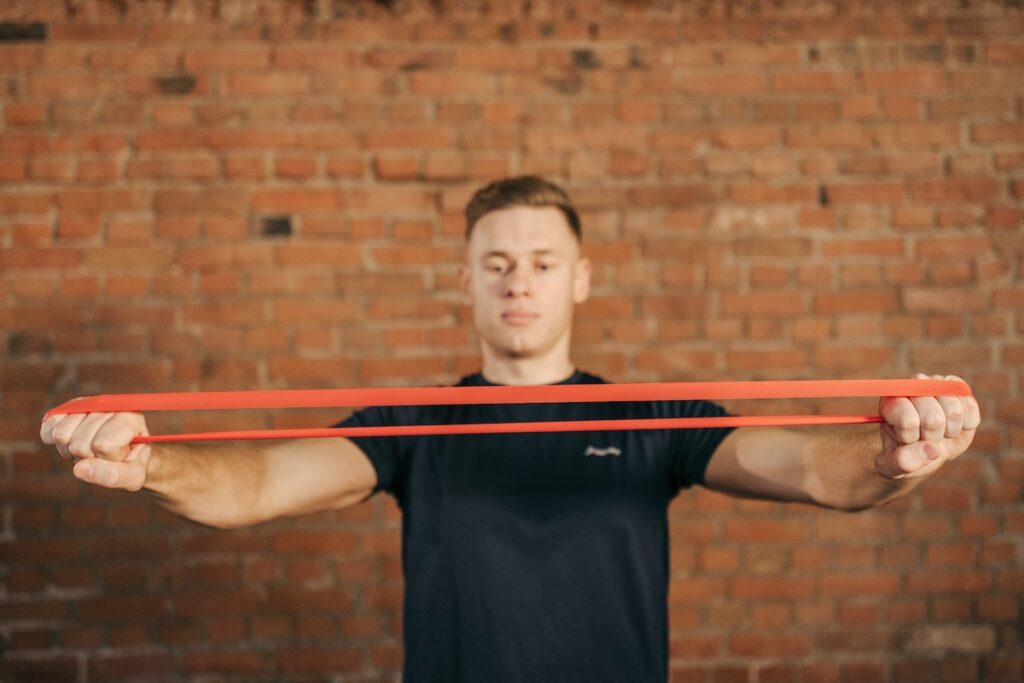 Image of a man using a resistance band. Source: Pexels -Tricep Exercises with Resistance Bands