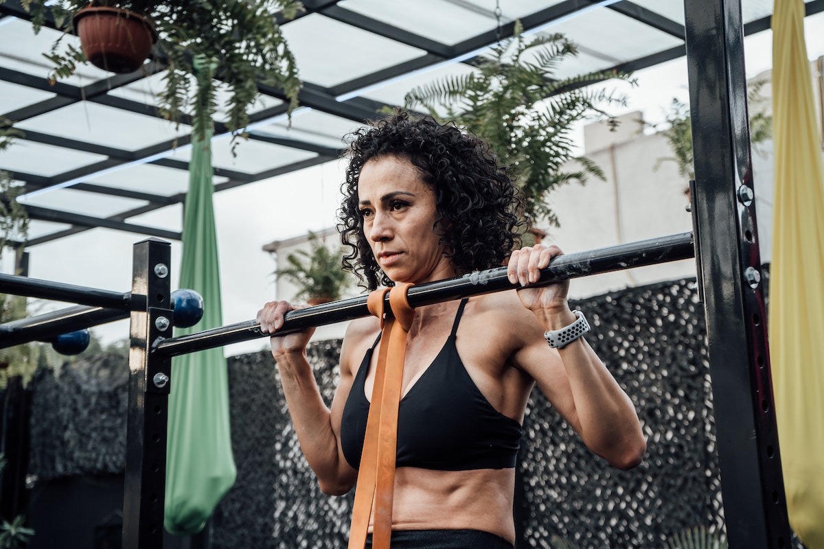 Image of a woman doing a resistance band pull up. Source: Pexels