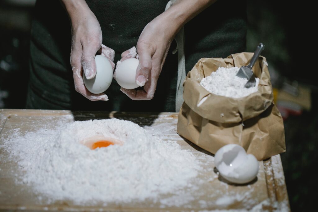 Image of a person mixing eggs with flour. Source Pexels