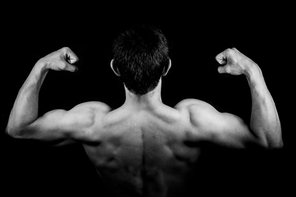 Image of a man flexing his muscles. Source: Pexels