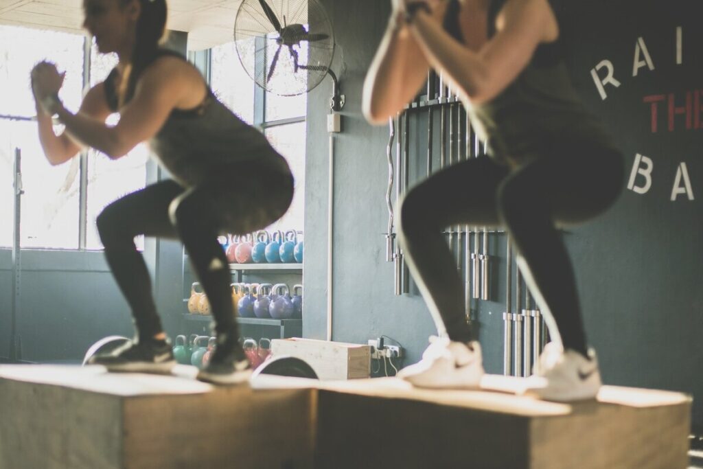 Image of two women doing air squats. Source: Unsplash
