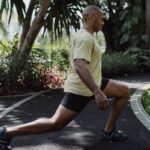 Image of a man doing leg day warm up exercise lunges. Source: Pexels