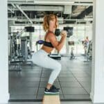 Image of a woman doing a squat exercise with dumbbells. Source: Unsplash