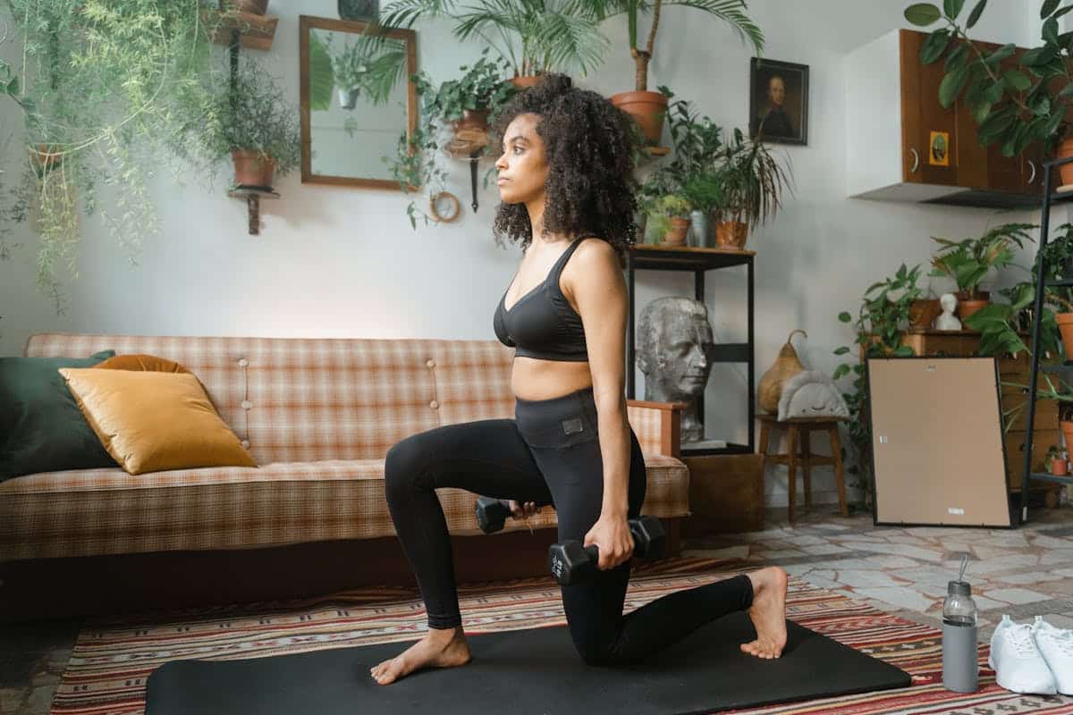 Image of A Woman Doing Lunges with Dumbbells at Home. Source: Pexels