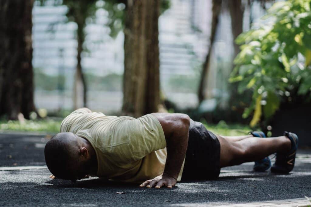 image of a man doing push ups on concrete floor. Source: pexels
