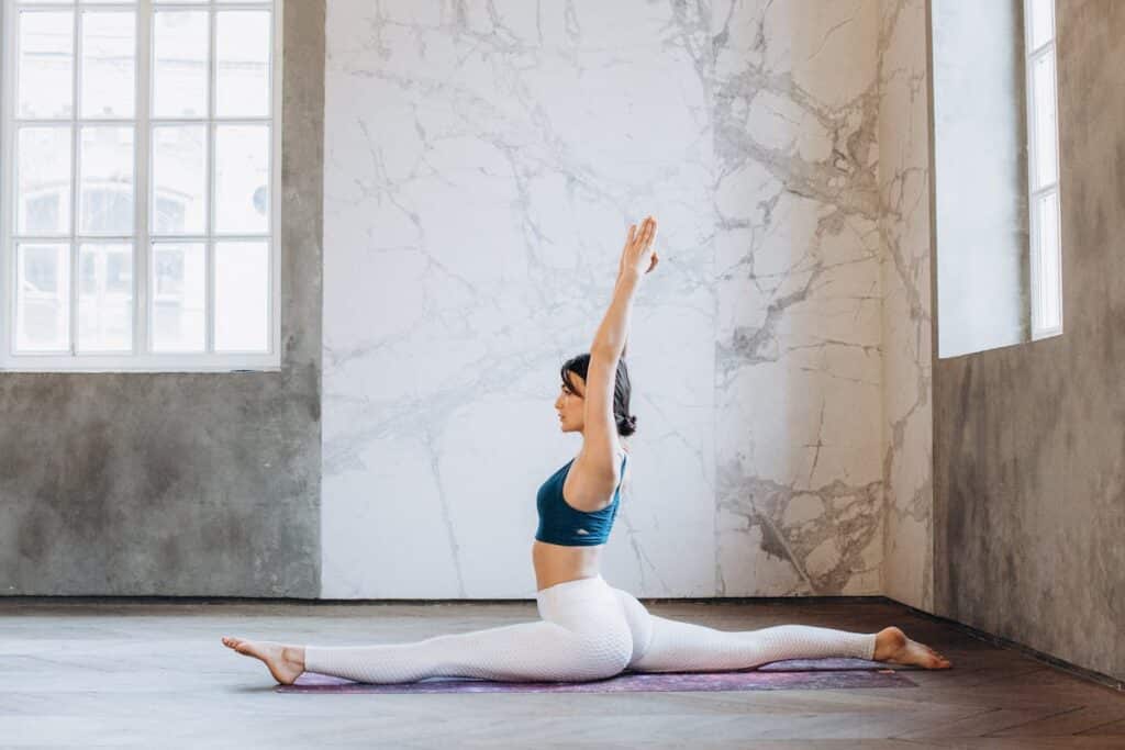 Image of a flexible woman in a split yoga position. 